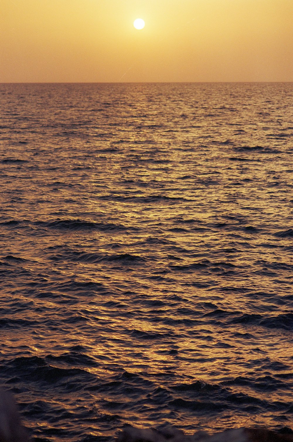 Un grande specchio d'acqua con un tramonto sullo sfondo