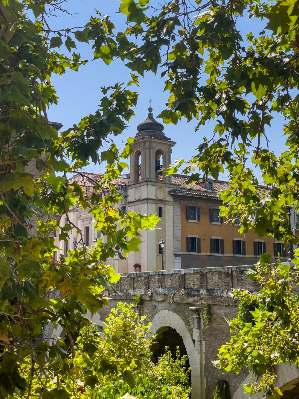 a building with a clock tower is seen through the trees