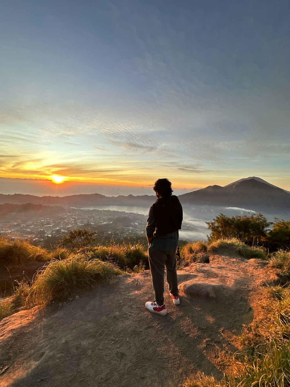 a person standing on top of a hill at sunset