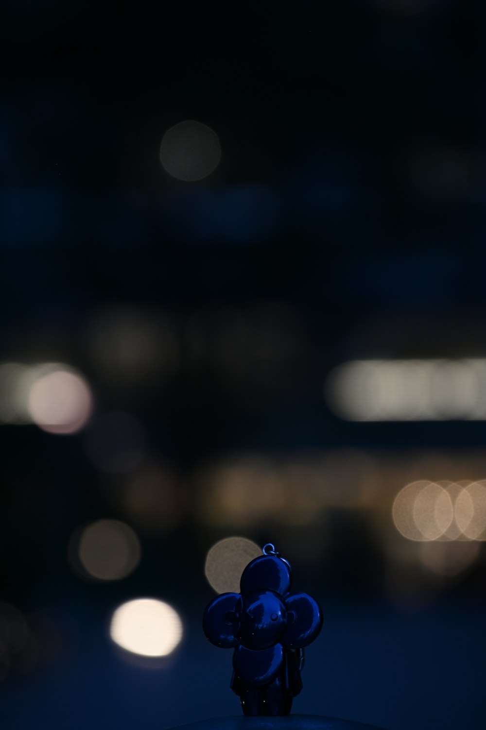 a small blue teddy bear sitting on top of a table