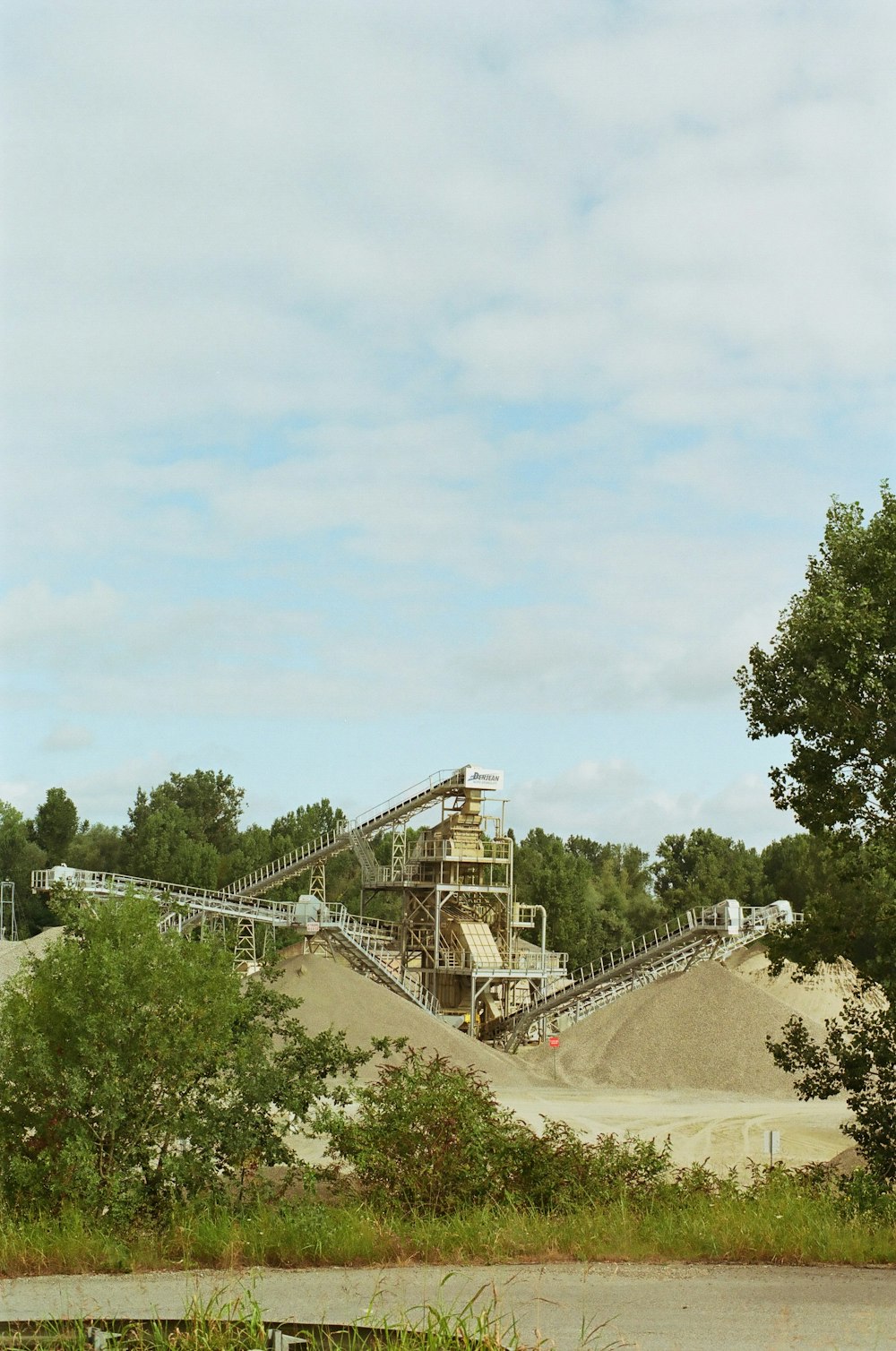 a large pile of dirt sitting next to a forest