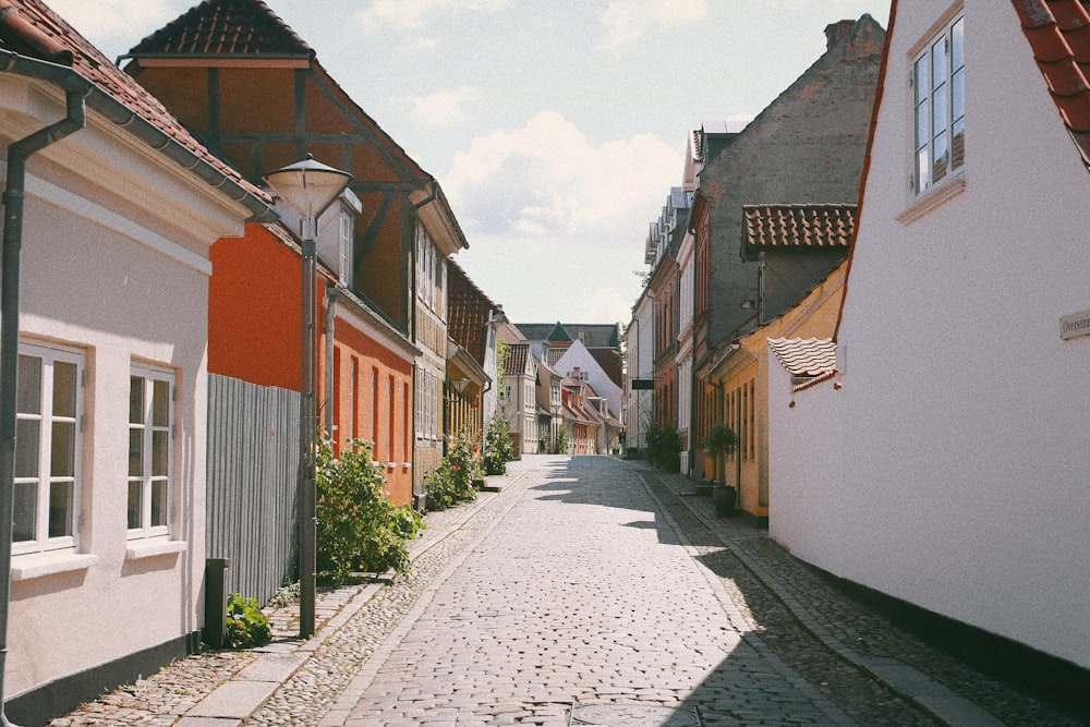 a narrow cobblestone street lined with houses