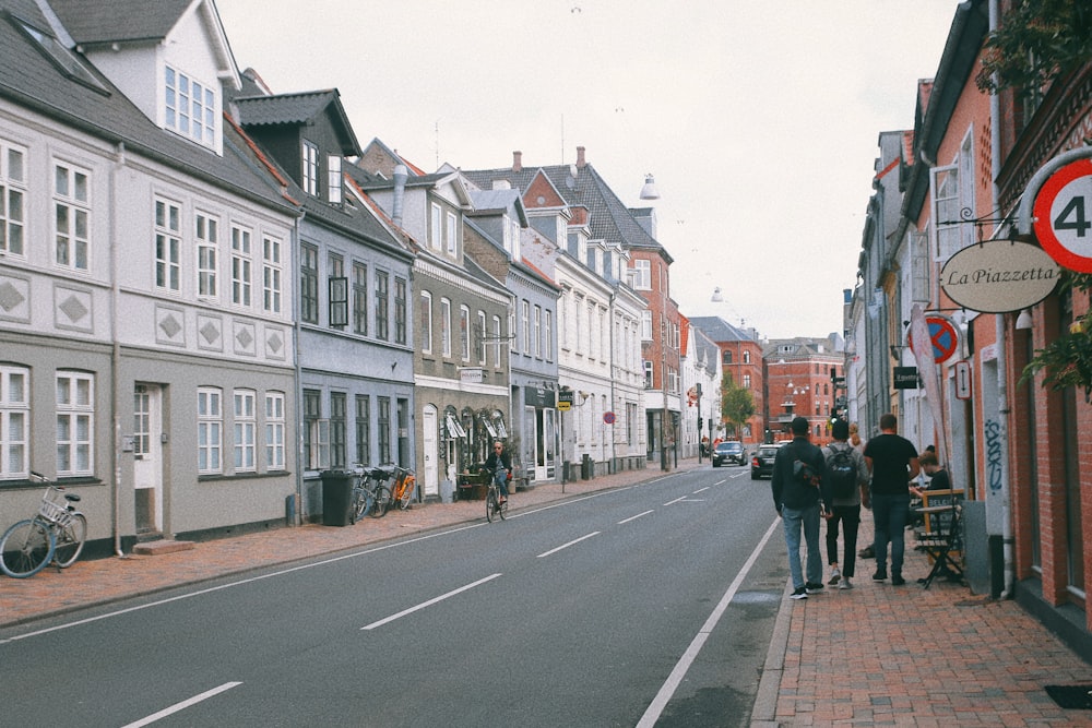 Eine Gruppe von Menschen, die eine Straße neben hohen Gebäuden entlang gehen