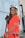a woman in an orange safety vest holding a baseball bat