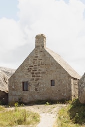 a stone house with a thatched roof