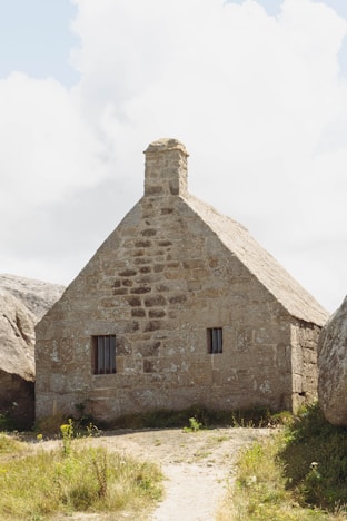 a stone house with a thatched roof
