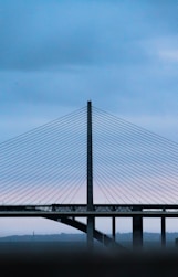a bridge with a plane flying over it