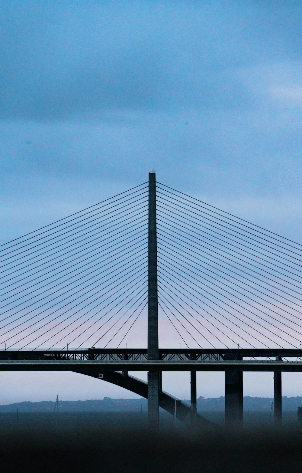 a bridge with a plane flying over it