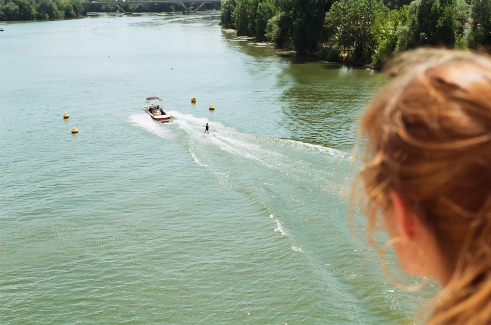 a woman looking at a boat in the water