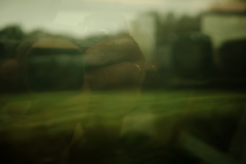 Una foto borrosa del reflejo de una persona en una ventana