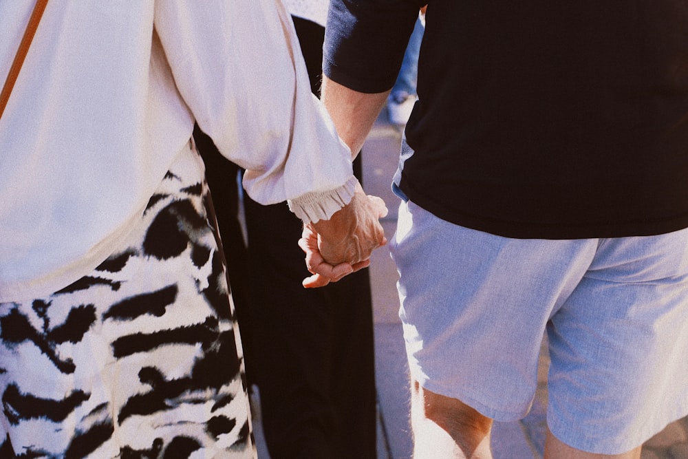 a group of people holding hands walking down a street