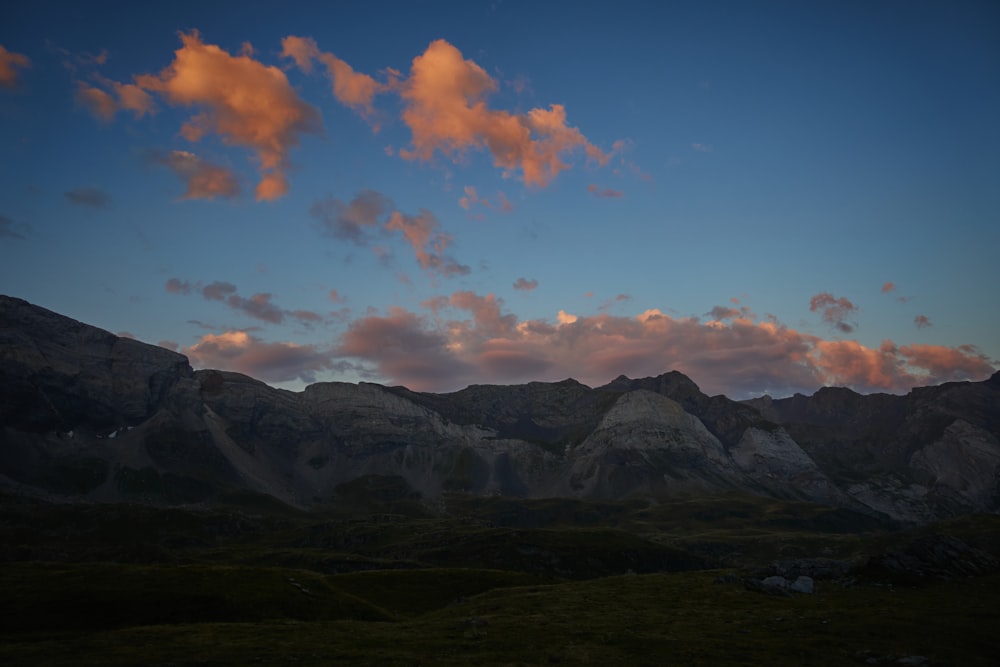 a mountain range with a few clouds in the sky