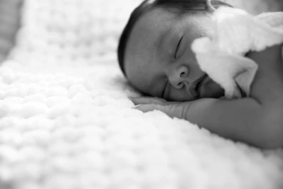 a black and white photo of a sleeping baby