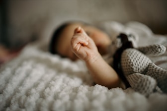 a close up of a baby laying on a blanket