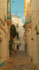 a narrow alley way with a bed on a balcony
