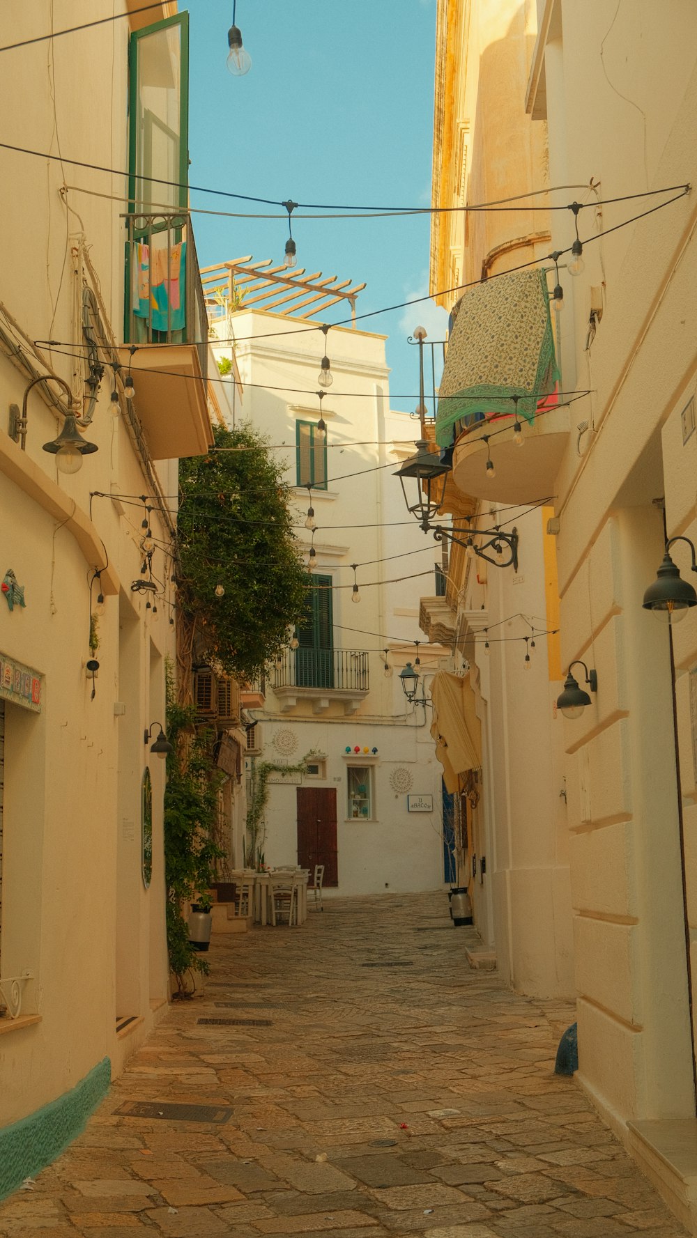 a narrow alley way with a bed on a balcony