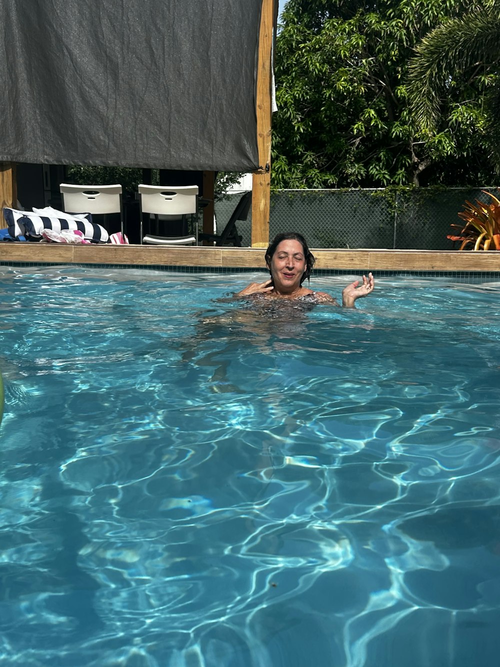 a woman in a swimming pool with a frisbee