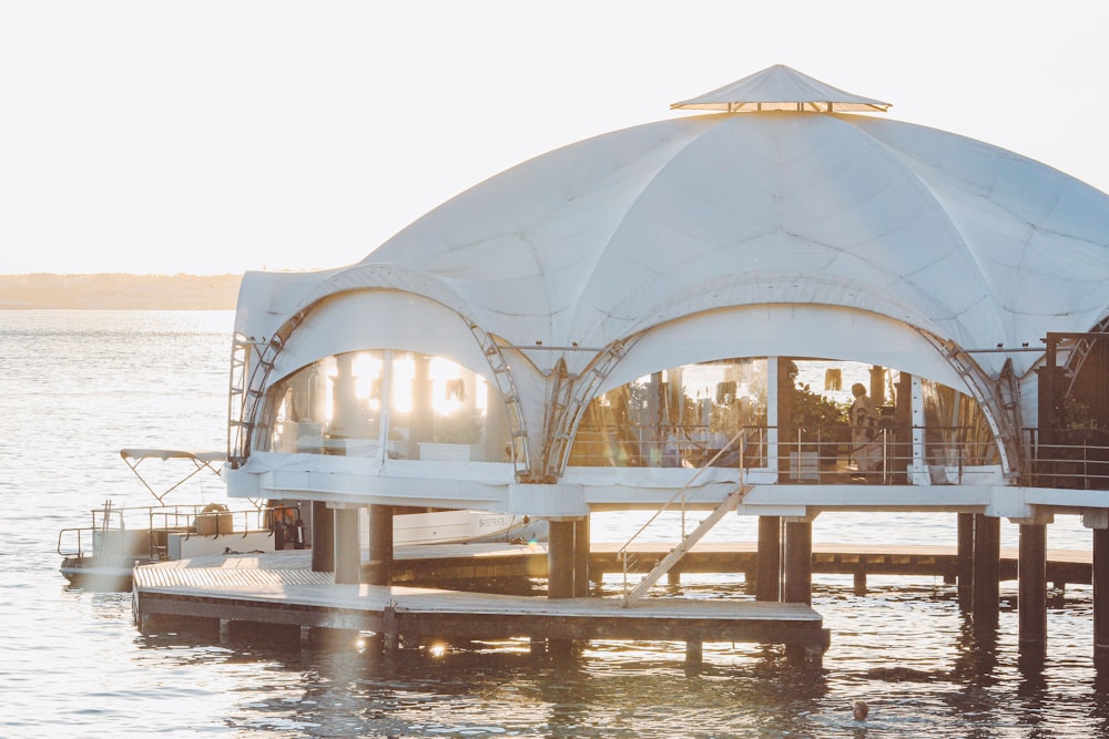 a large white tent sitting on top of a body of water