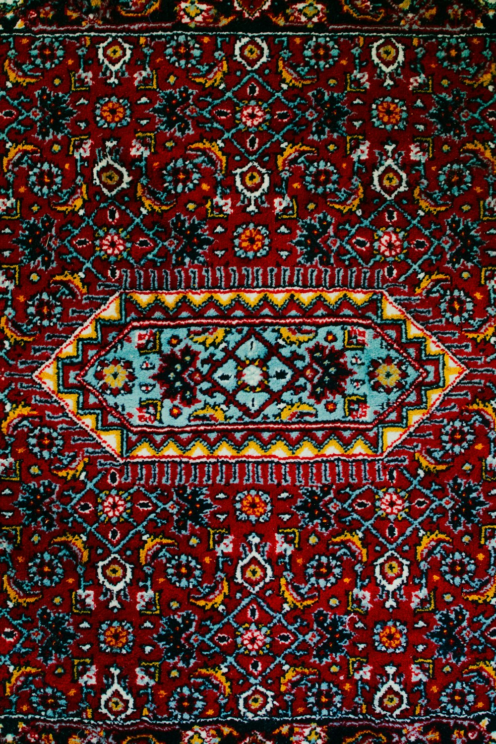 a red rug with a blue and yellow border