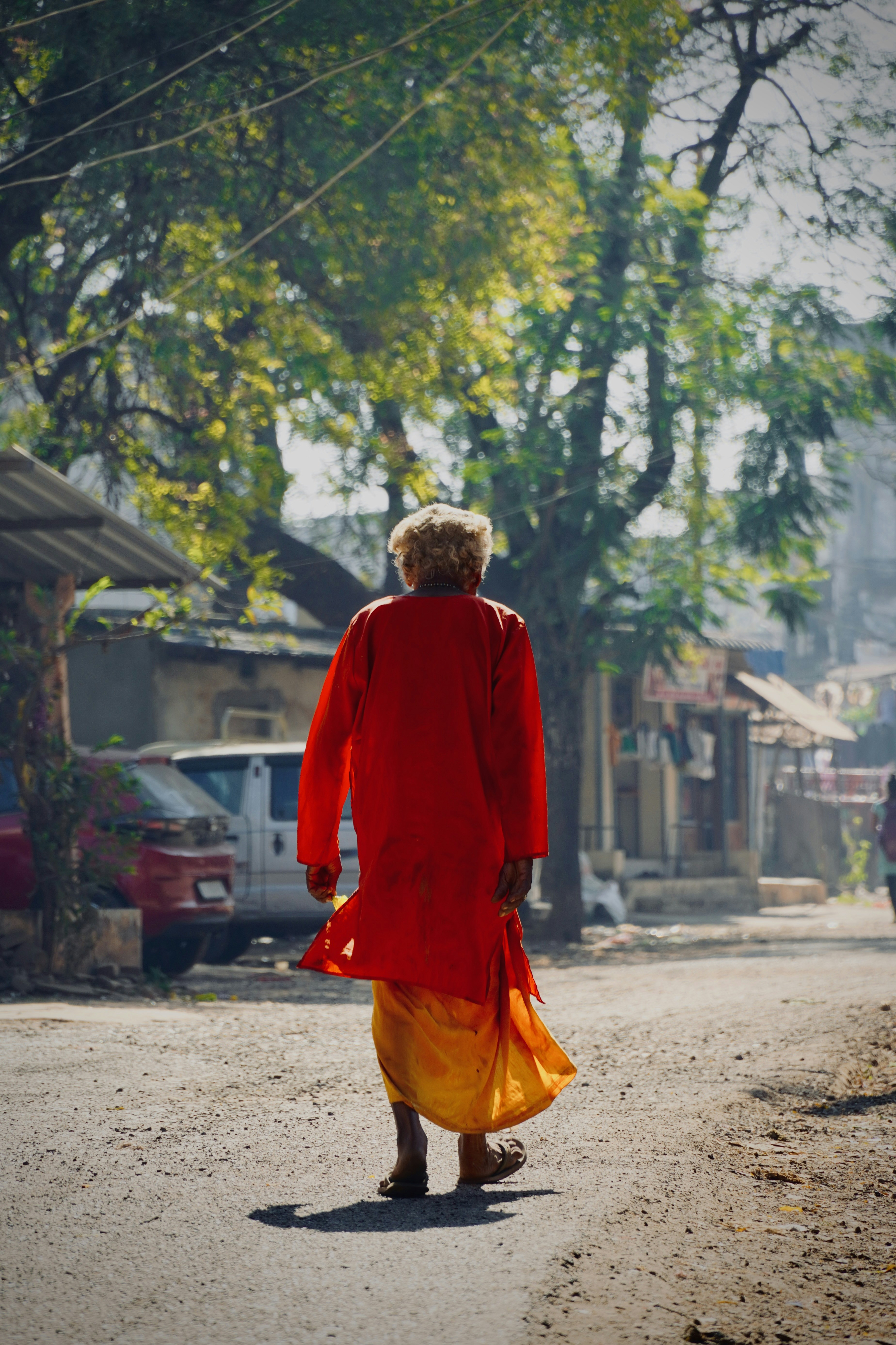 Una persona in una giacca rossa che cammina lungo una strada