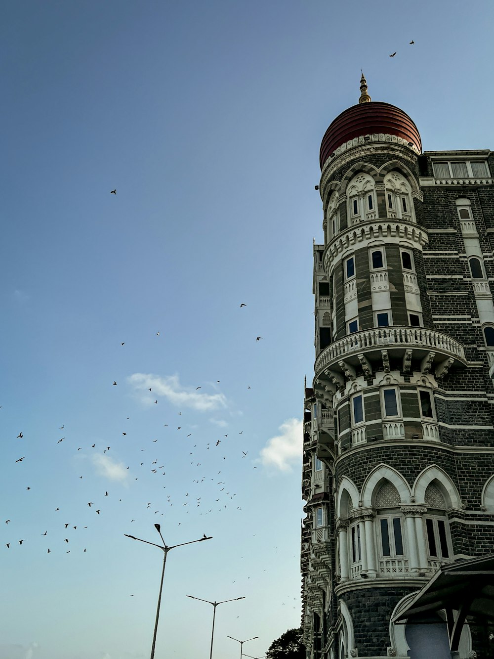 a very tall building with a lot of birds flying around it