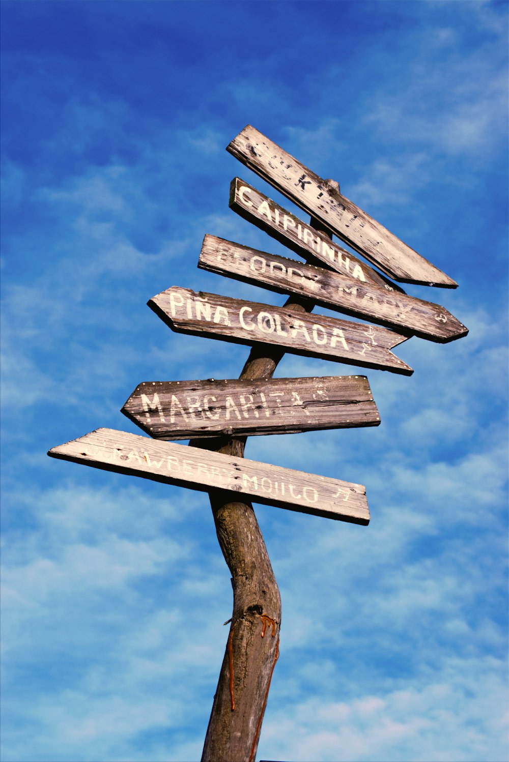 a wooden pole with a bunch of signs on it