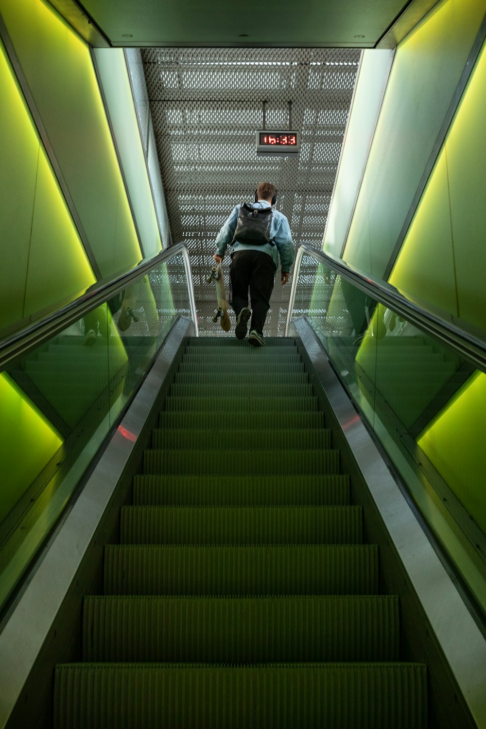 a man walking down an escalator with a backpack