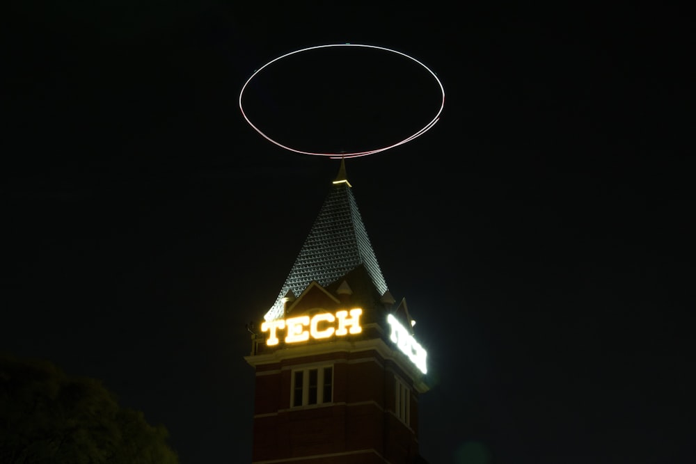 a clock tower with a neon sign on top of it