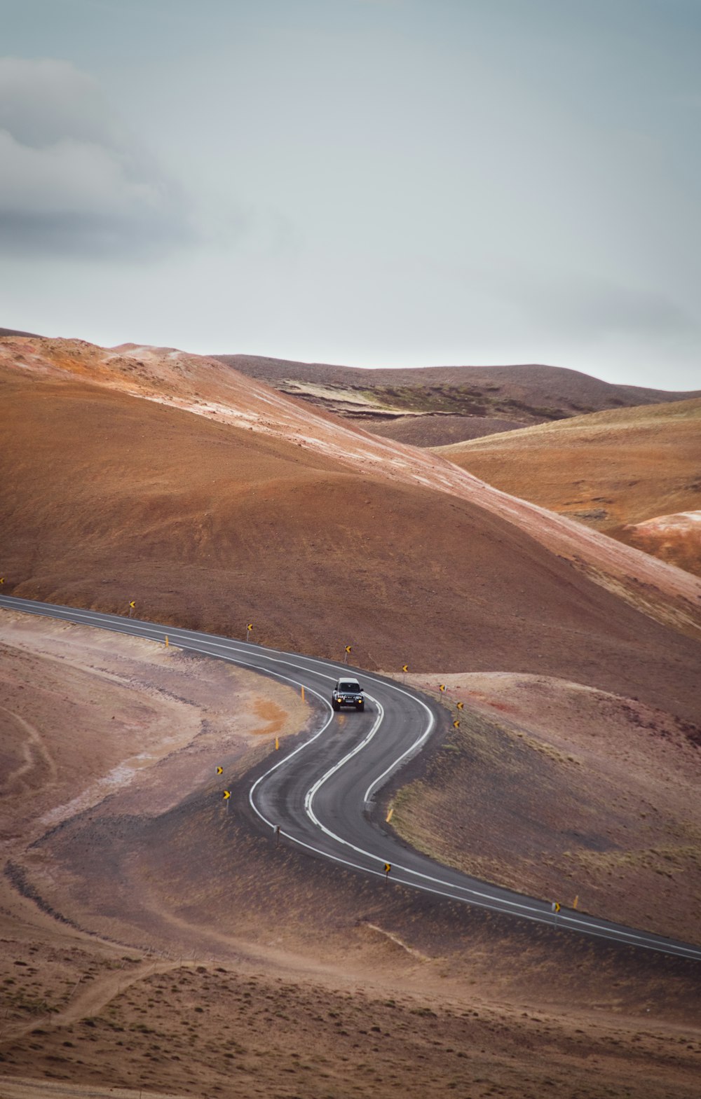 ein Auto, das eine kurvenreiche Straße in der Wüste hinunterfährt