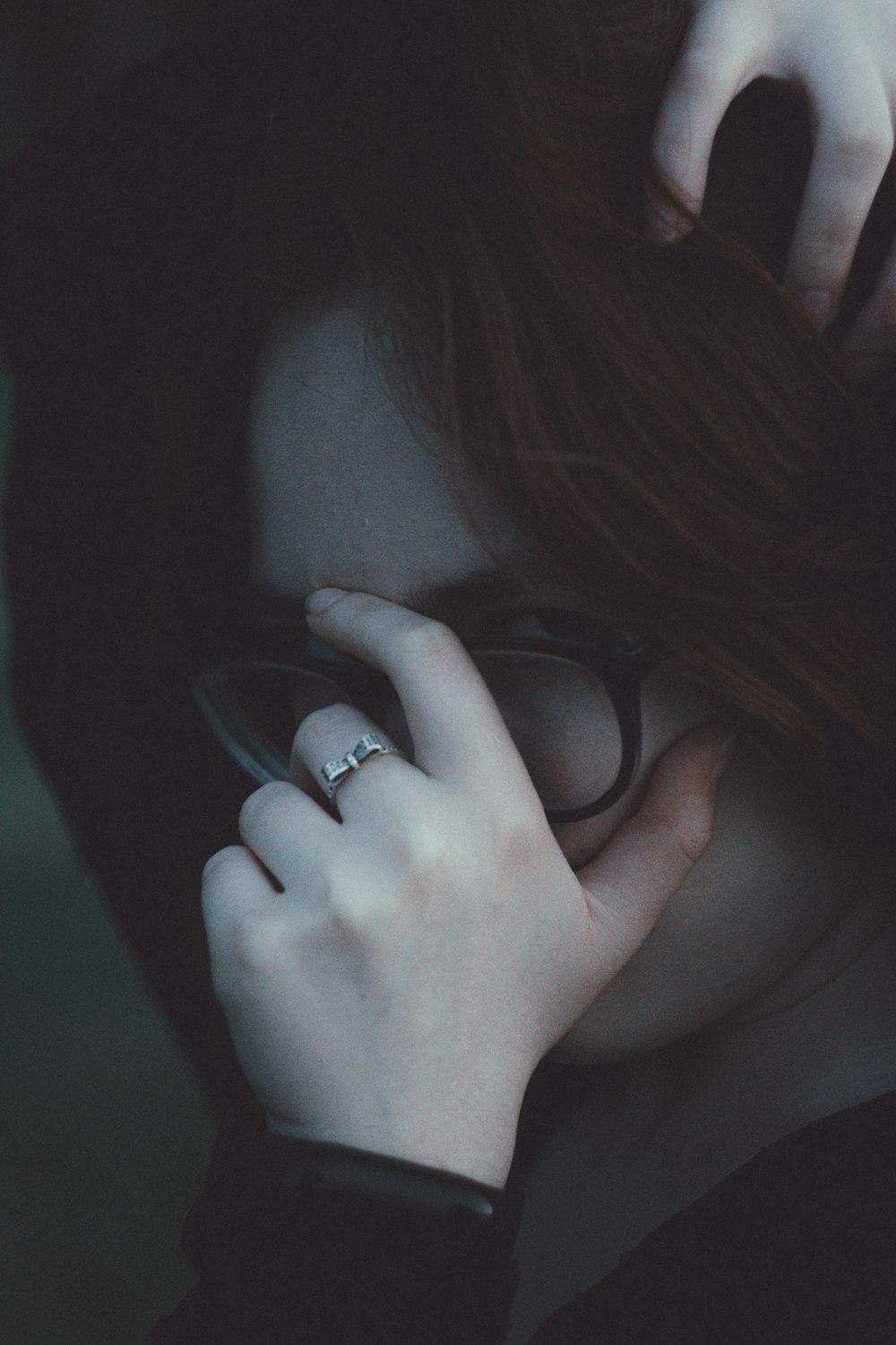 a woman with glasses and a ring on her finger