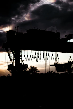Articulated crane lifting a heavy billboard at sunset on the Caribbean coast