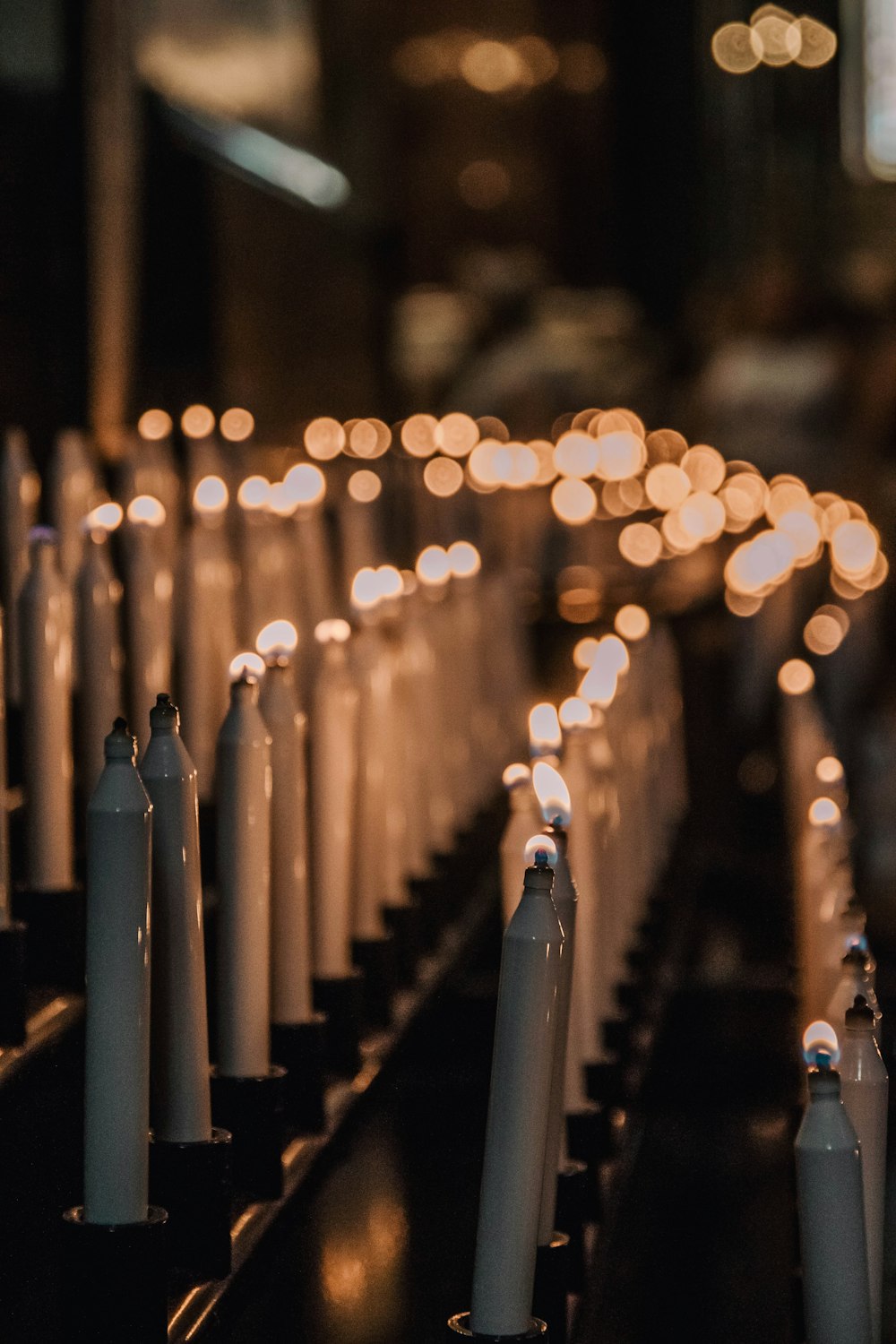 a row of white candles sitting on top of a table