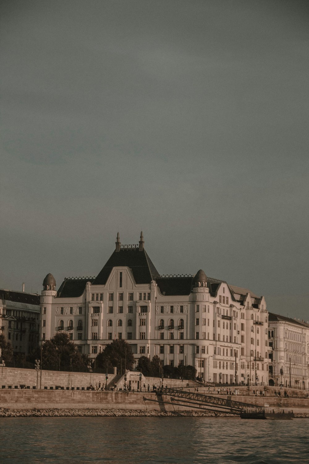 a large white building sitting next to a body of water