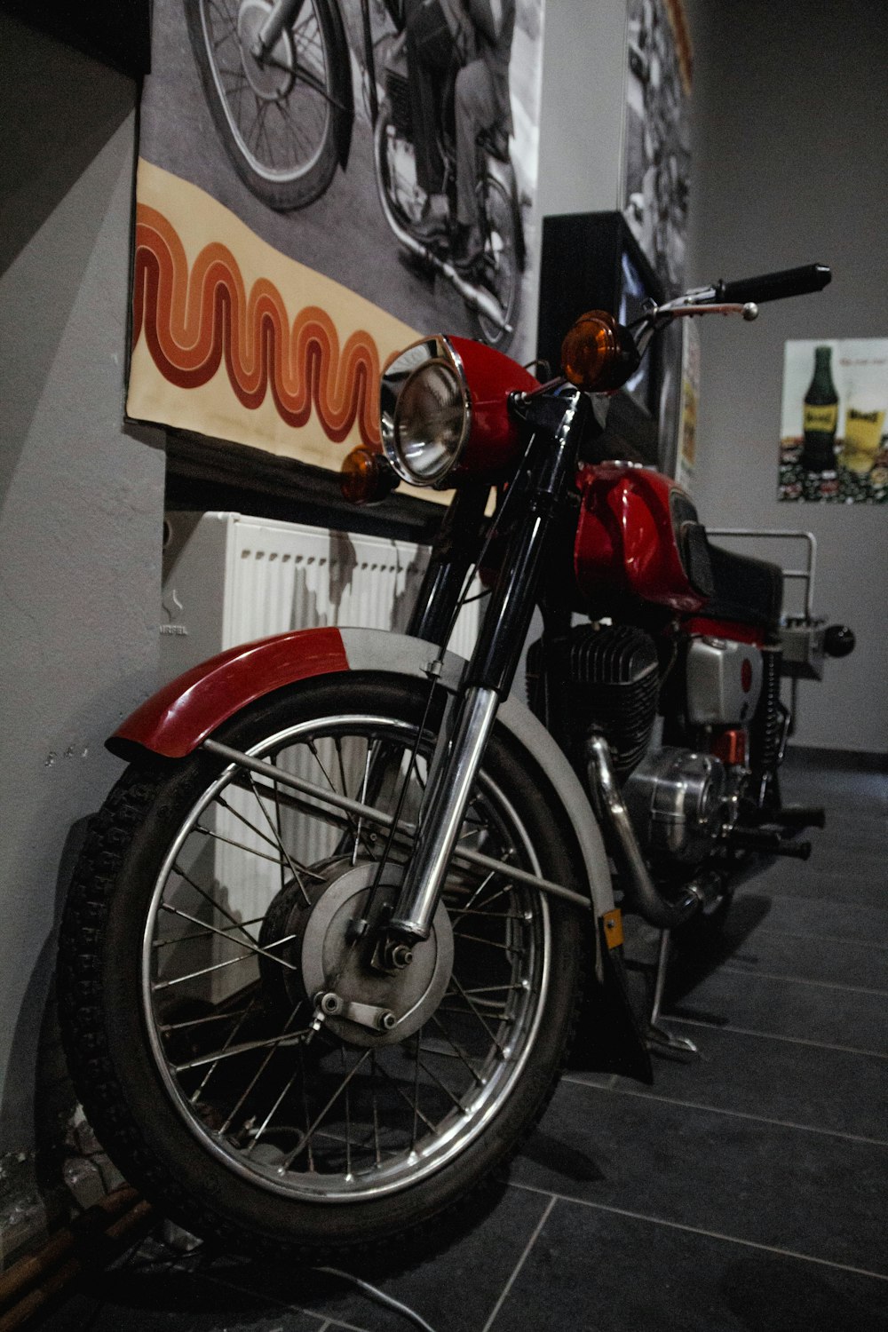 a red motorcycle parked next to a wall