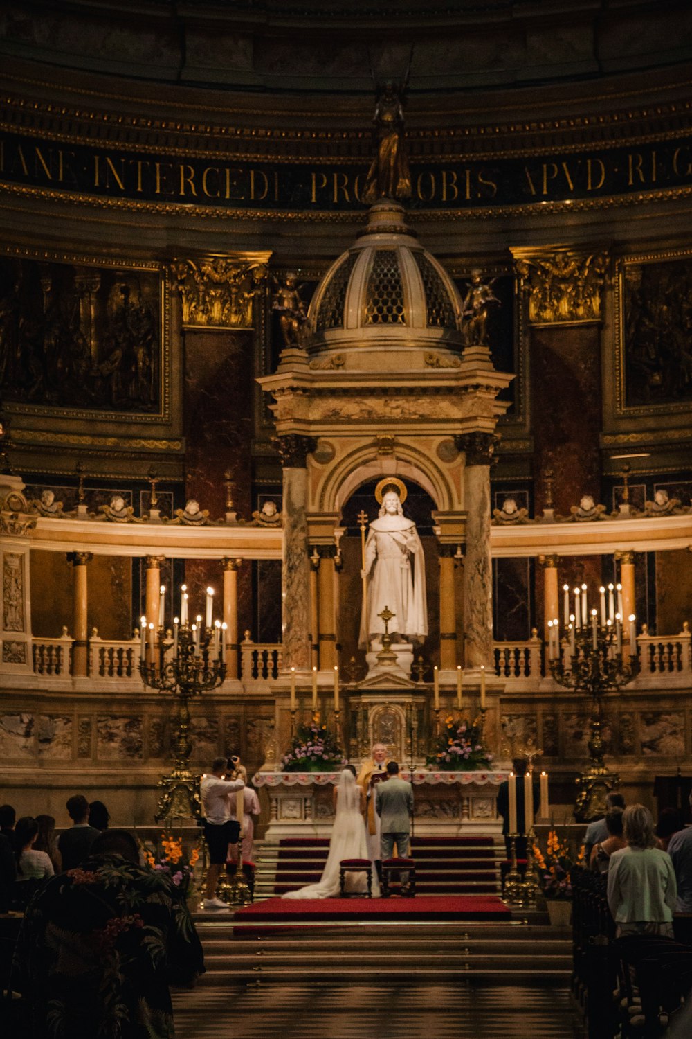 a bride and groom standing at the alter of a church