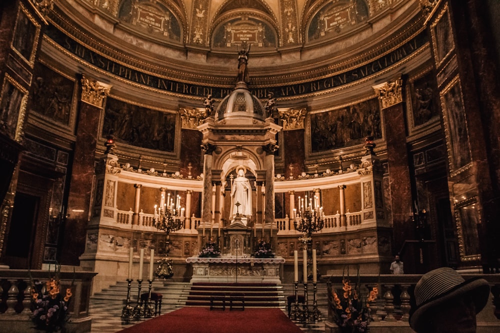 a church with a red carpet and a statue