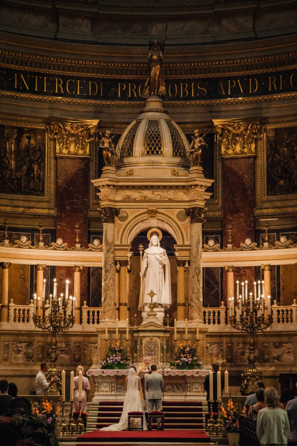 a bride and groom standing at the alter of a church