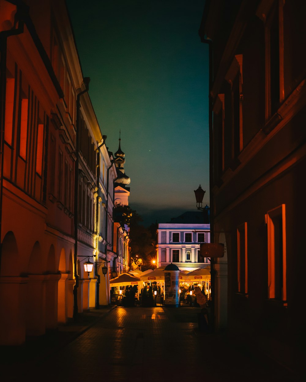 a city street at night with a clock tower in the background