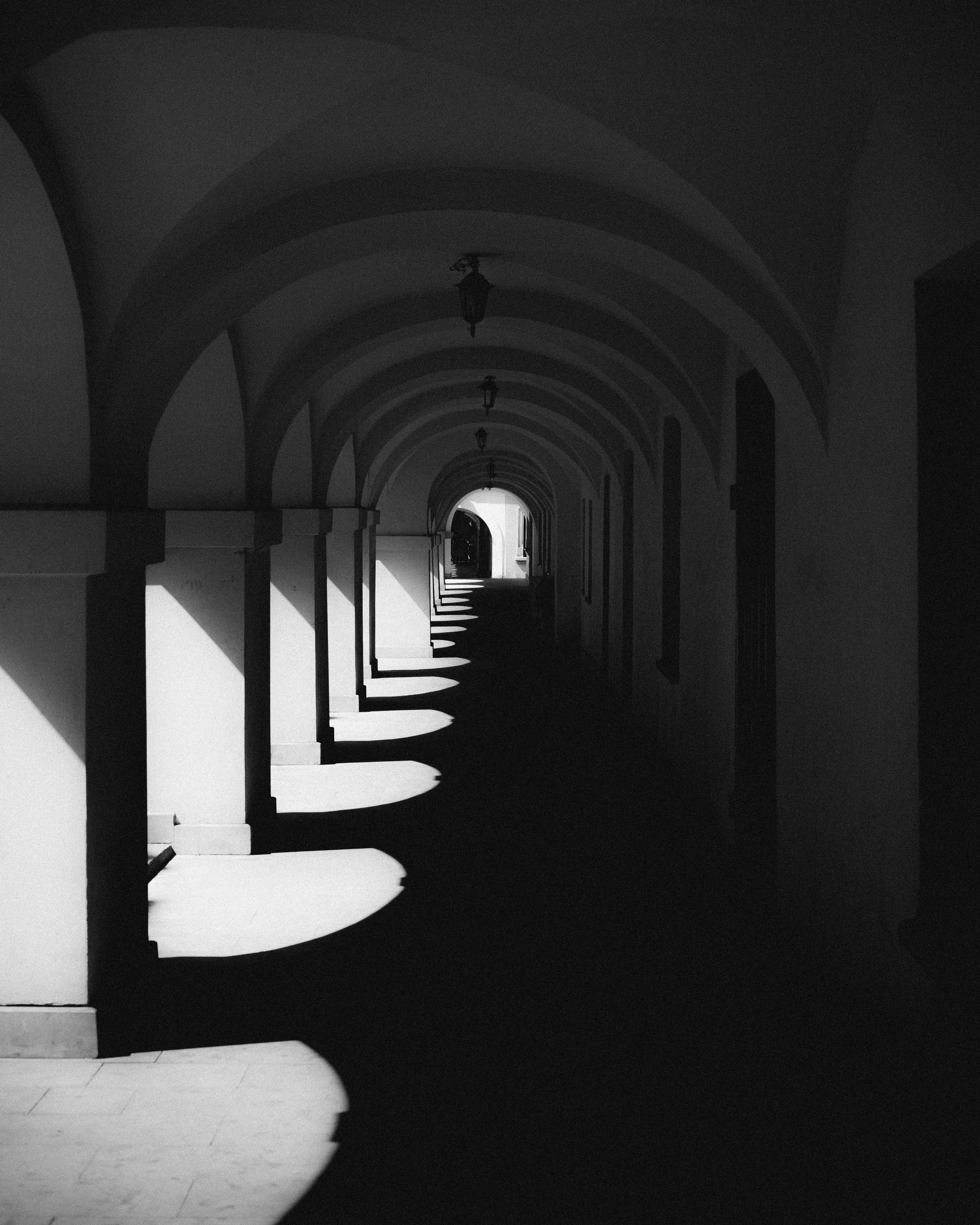 Une photo en noir et blanc d’un long couloir