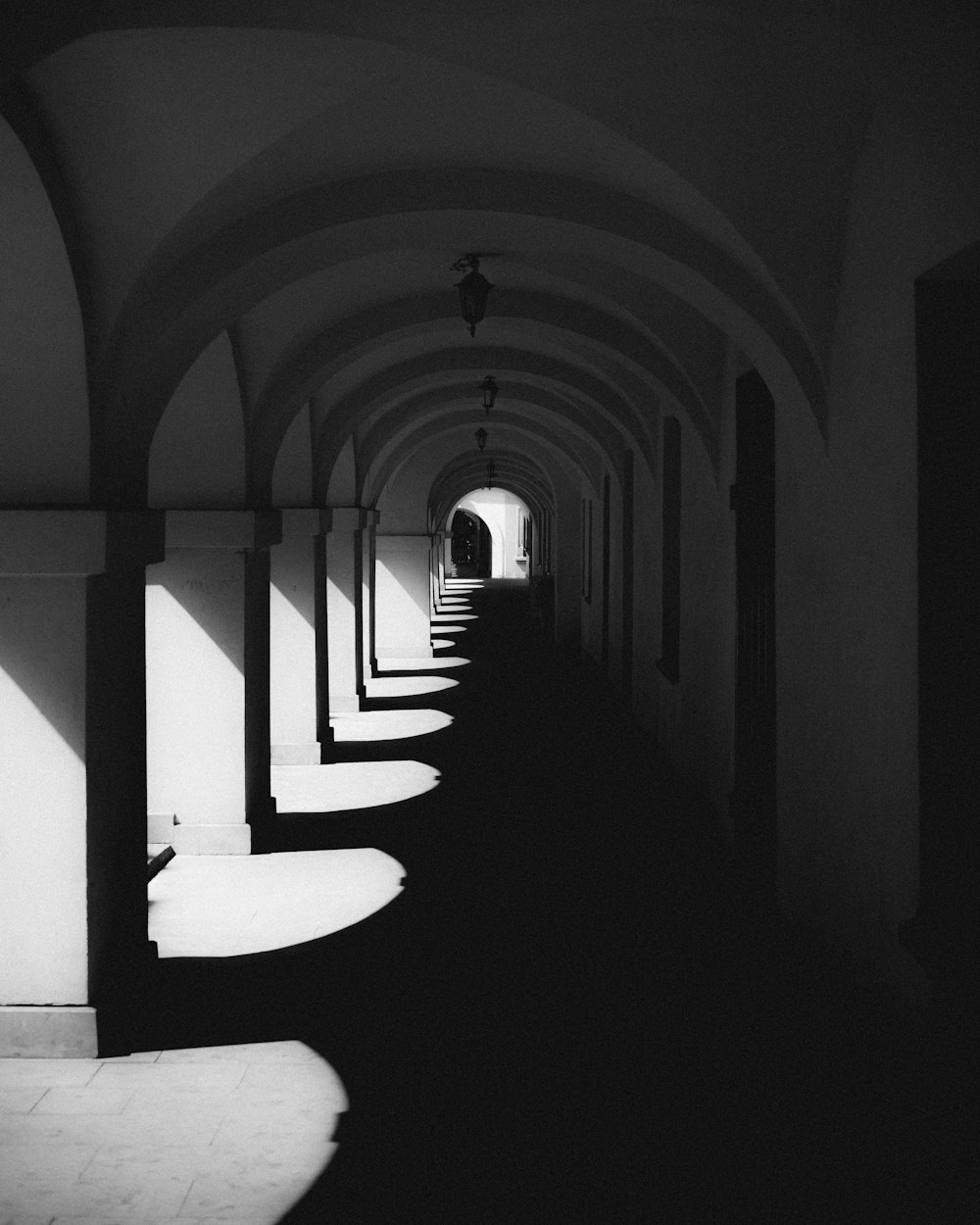 a black and white photo of a long hallway