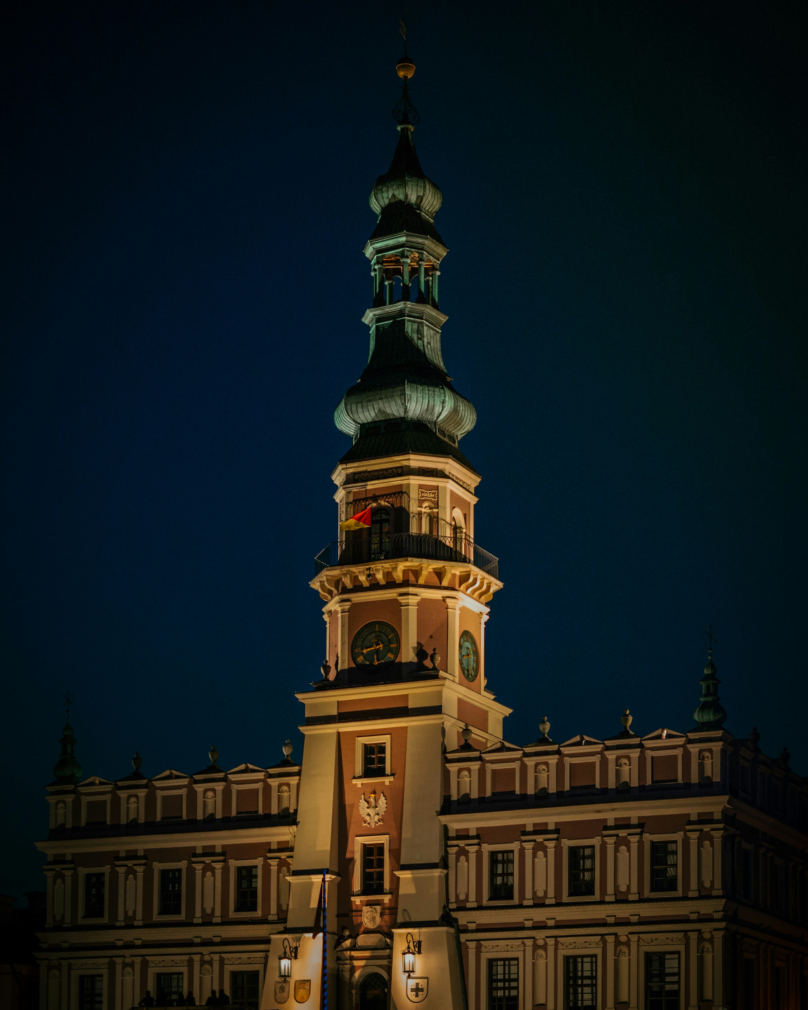 Un grand bâtiment avec une tour d’horloge éclairée la nuit