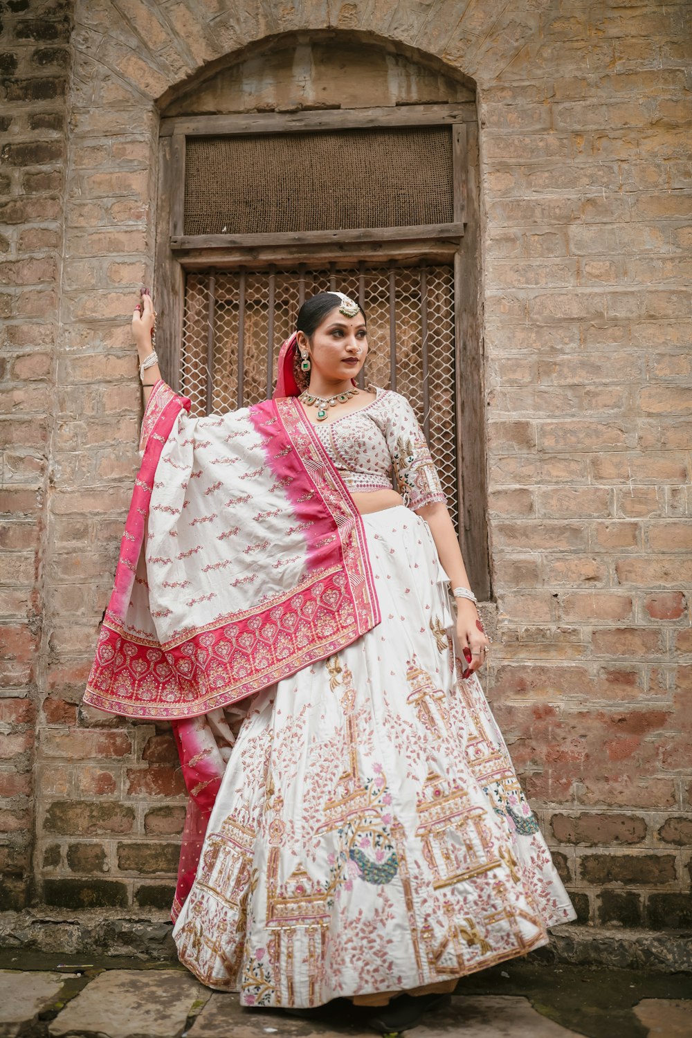 a woman standing in front of a brick building