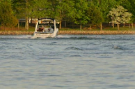 Motorboat engine being carefully cleaned and serviced on a sunny day.