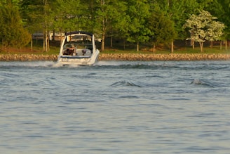 A calm Mazurian lake with a motorboat gliding smoothly near Giżycko harbor at sunset.