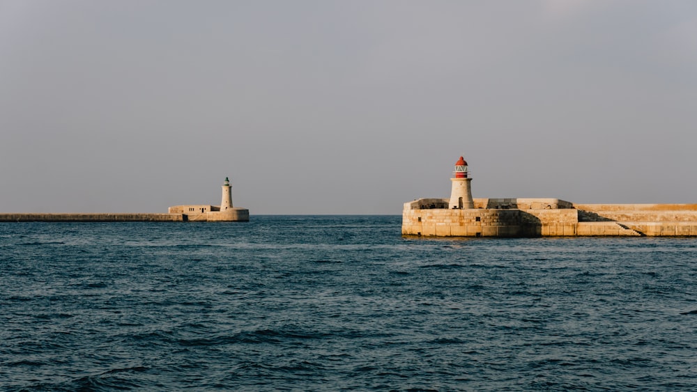 a light house sitting on top of a pier next to the ocean