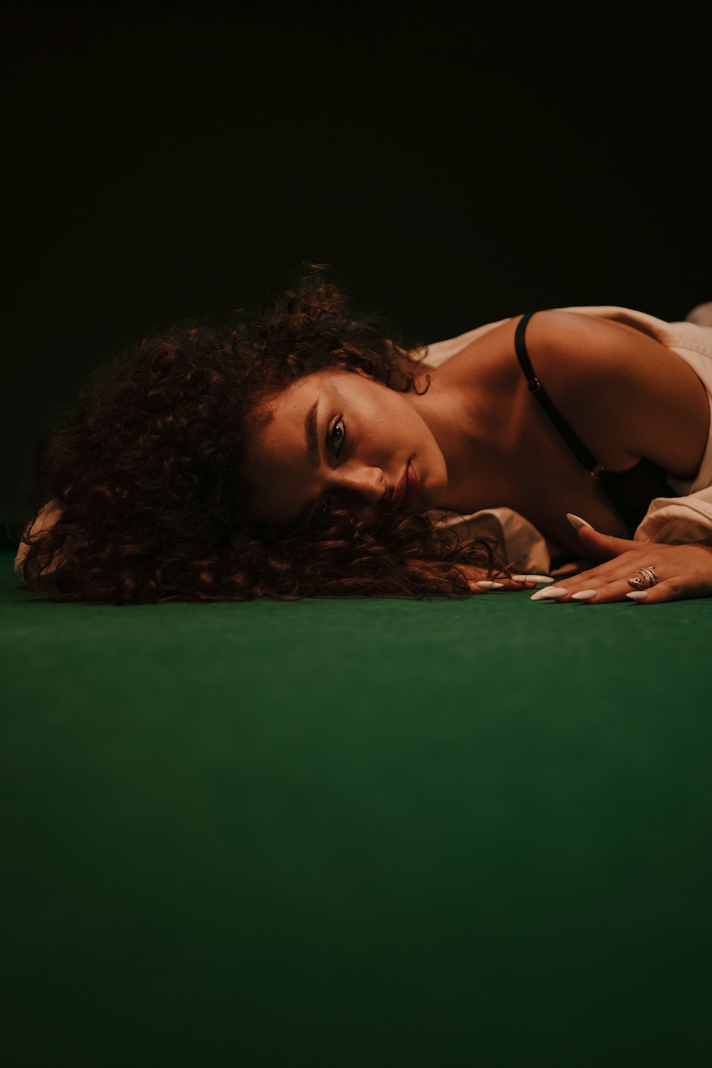 a woman laying on the ground with a green background