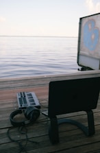 a laptop computer sitting on top of a wooden dock