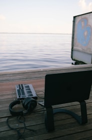 a laptop computer sitting on top of a wooden dock