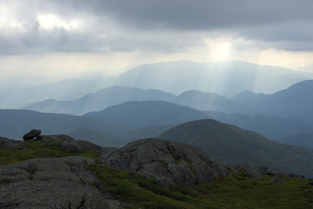 the sun shines through the clouds over the mountains