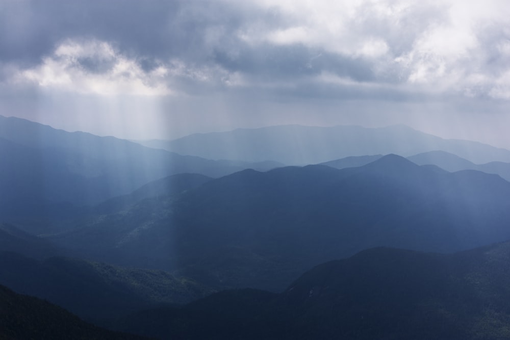 the sun shines through the clouds over the mountains